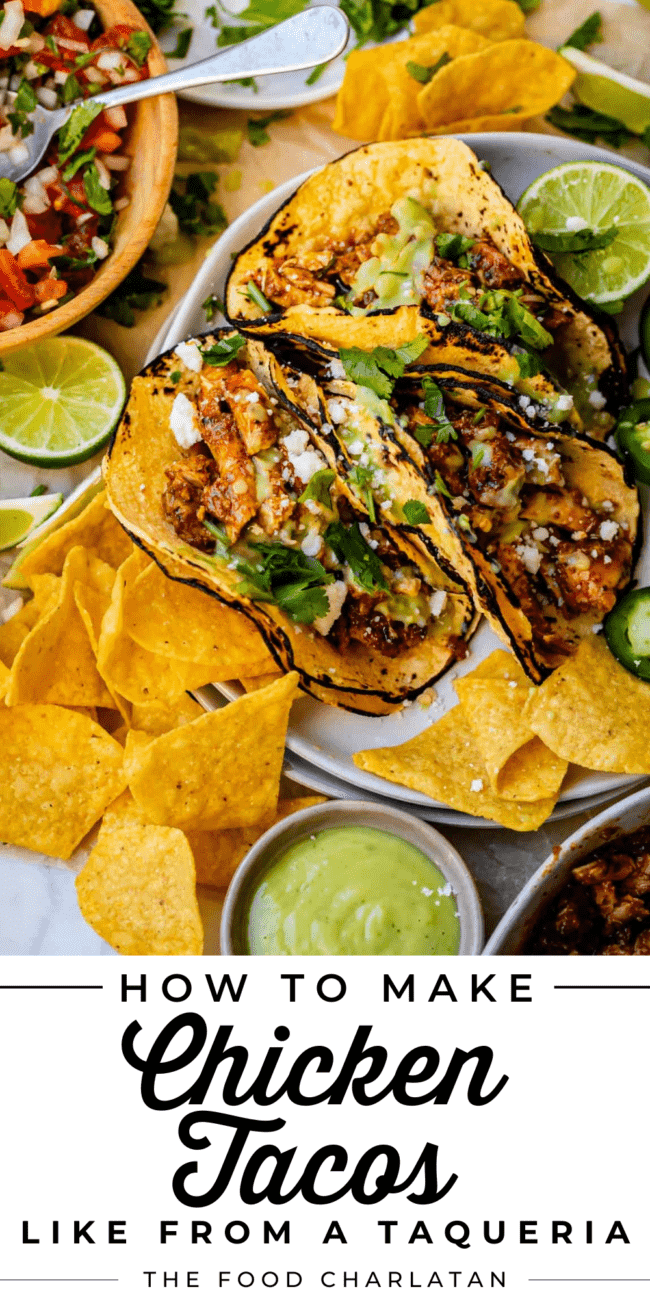 3 slow cooker chicken tacos on a plate, with a bowl of pico de gallo and chips and salsa.