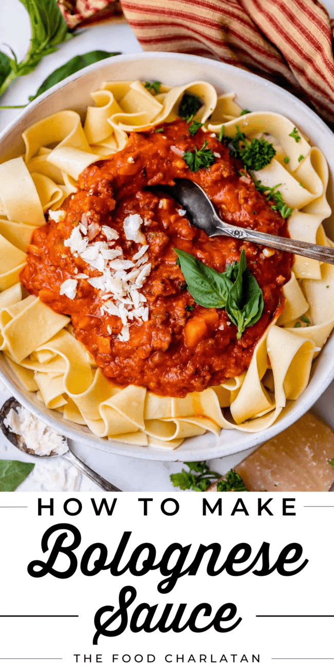 bowl of pappardelle noodles with red sauce and basil and spoon.