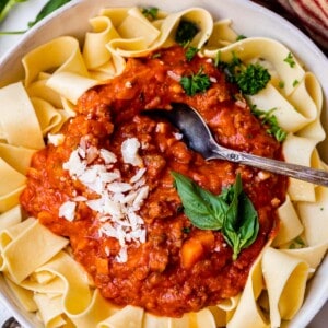looking down at a bowl with noodles with a large serving of authentic bolognese sauce on top.