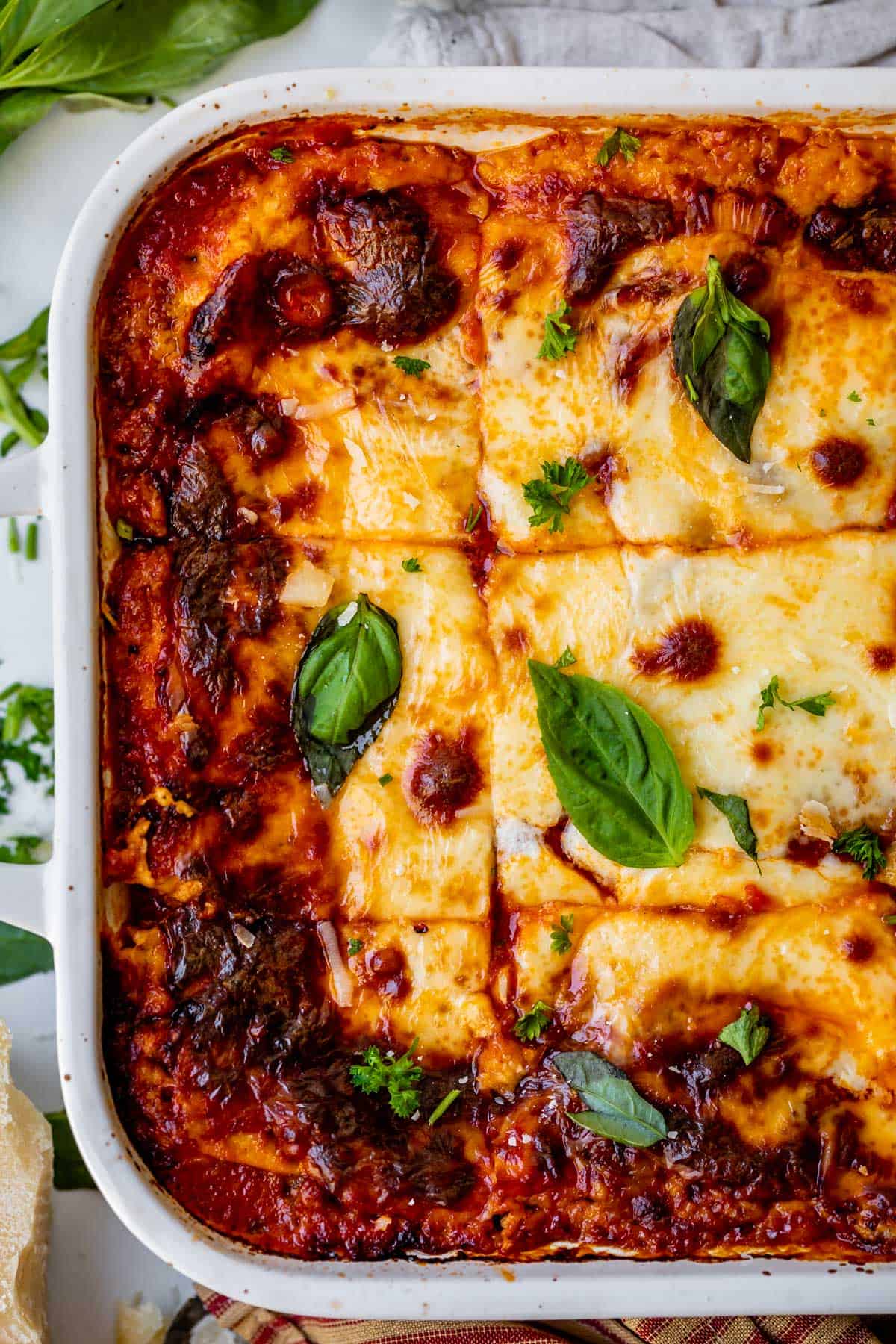 overhead shot of a white casserole dish with sliced lasagna.