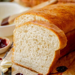 a thick slice of easy white bread leaning against the remaining loaf.