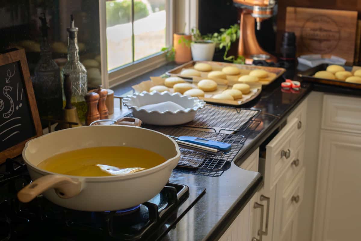 fry station all ready to go - hot oil, cooling rack, sugar for coating, risen donuts, etc.