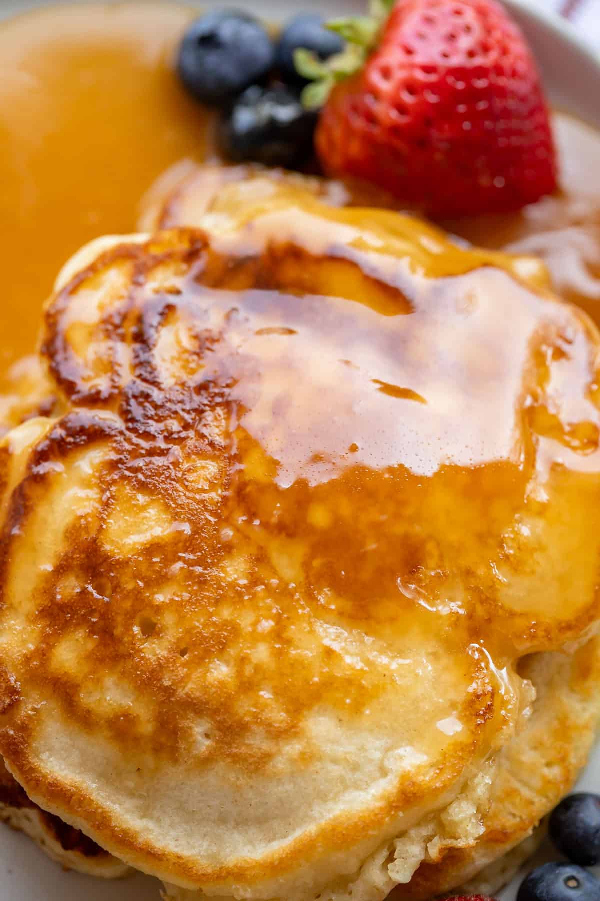 overhead shot of buttermilk syrup recipe on a plate with fruit.