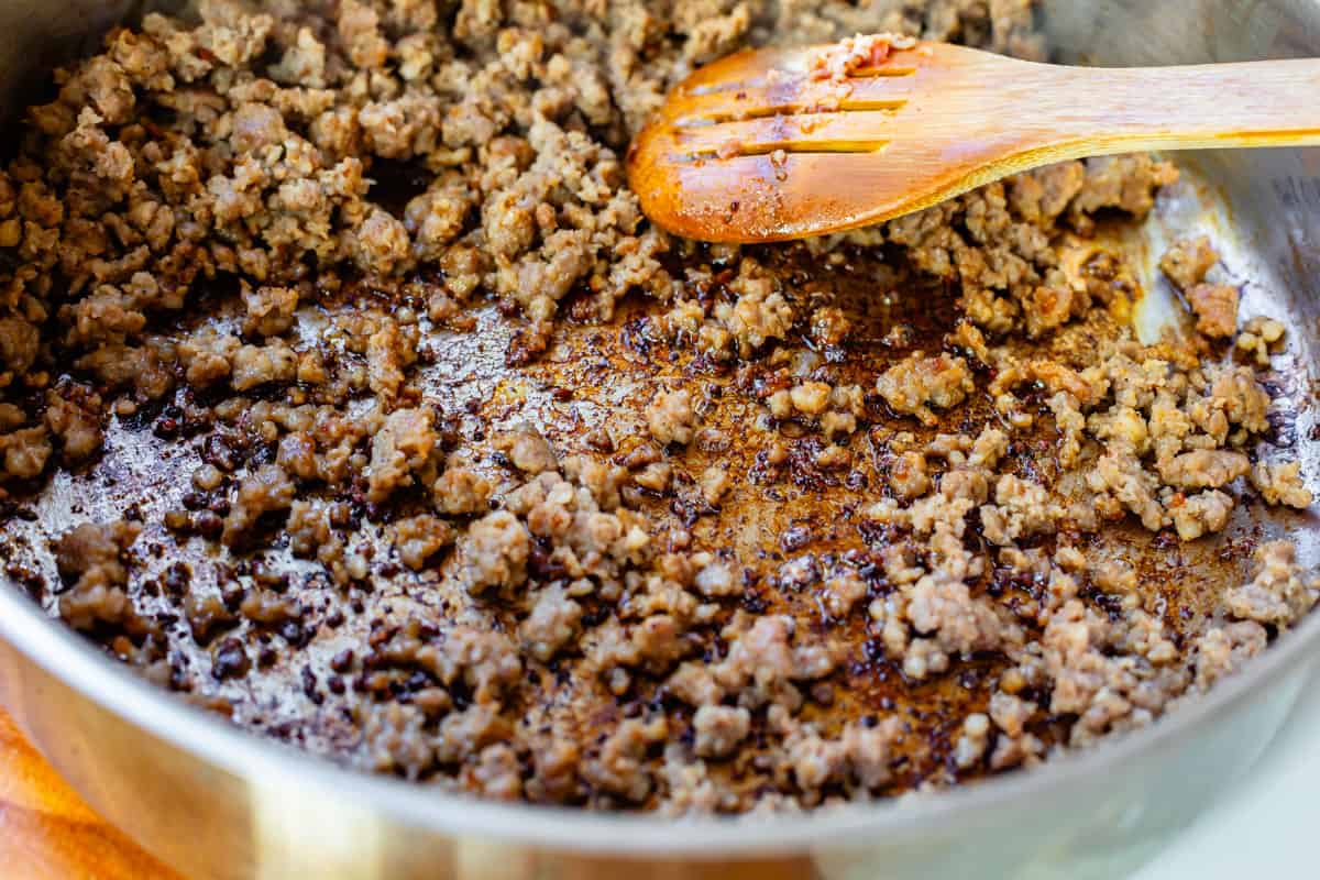 Cooking ground sausage in pan of bacon