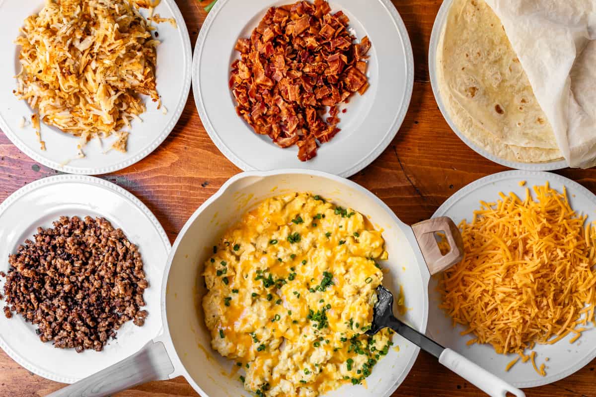 breakfast burrito ingredients laid out on plates, ready for assembly. 