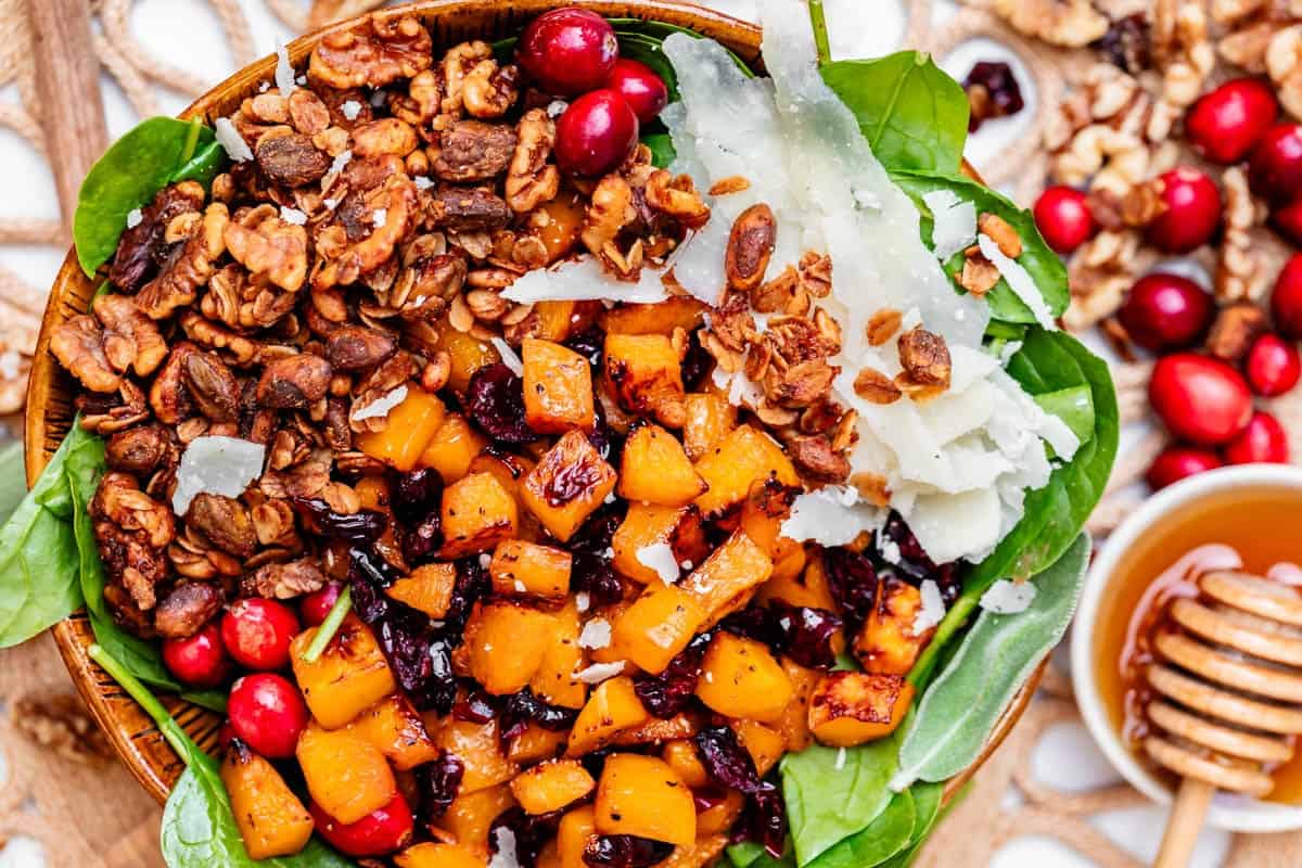 looking down on a bowl filled with squash salad - savory granola, cranberries, squash, etc.