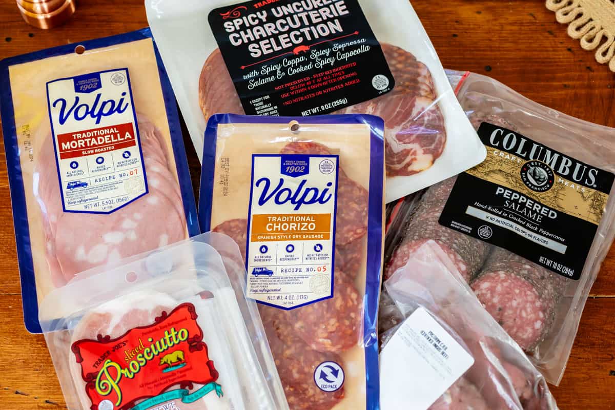 Assortment of packaged deli meats including mortadella, procsiutto, salame, chorizo, and roast beef.