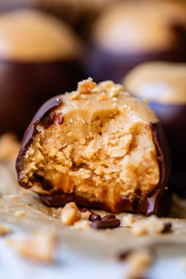 a bite taken out of peanut butter ball covered in chocolate.