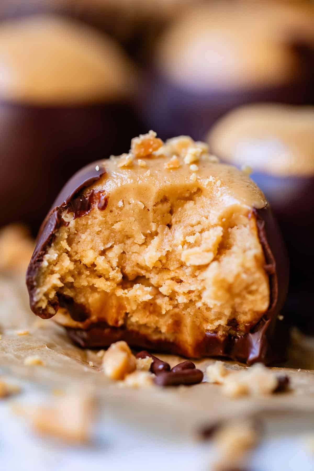 a bite taken out of peanut butter ball covered in chocolate.