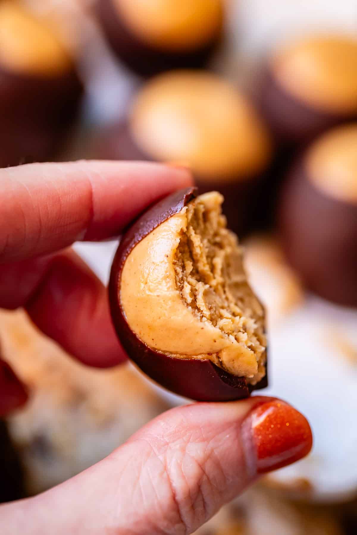 Bite of buckeye taken out held in fingers.