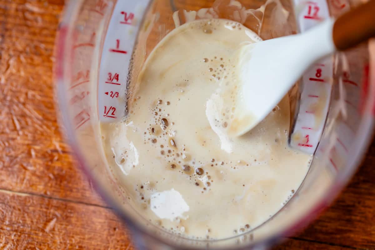 yeast bubbling away in water in a liquid measuring cup prior to adding other ingredients.