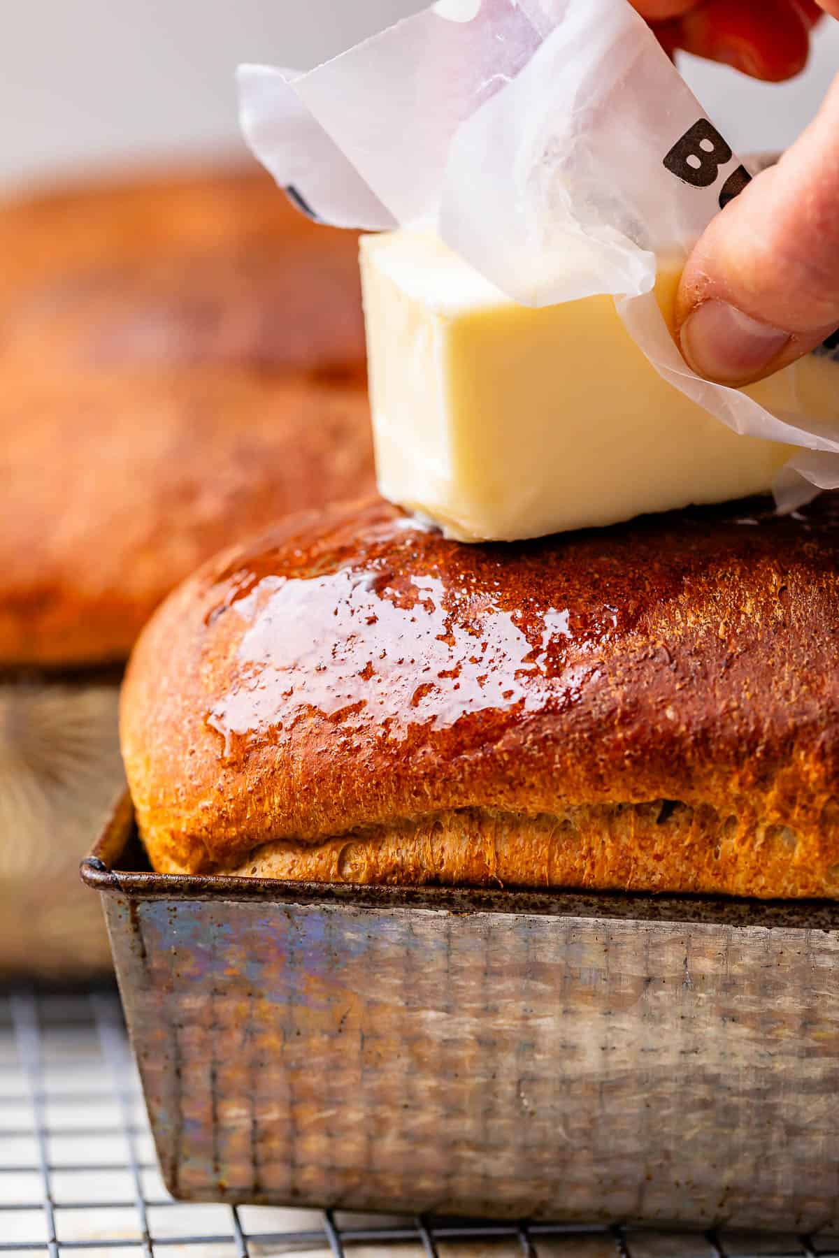 buttering the top of the baked loaf, using the wax paper it comes into hold the butter.