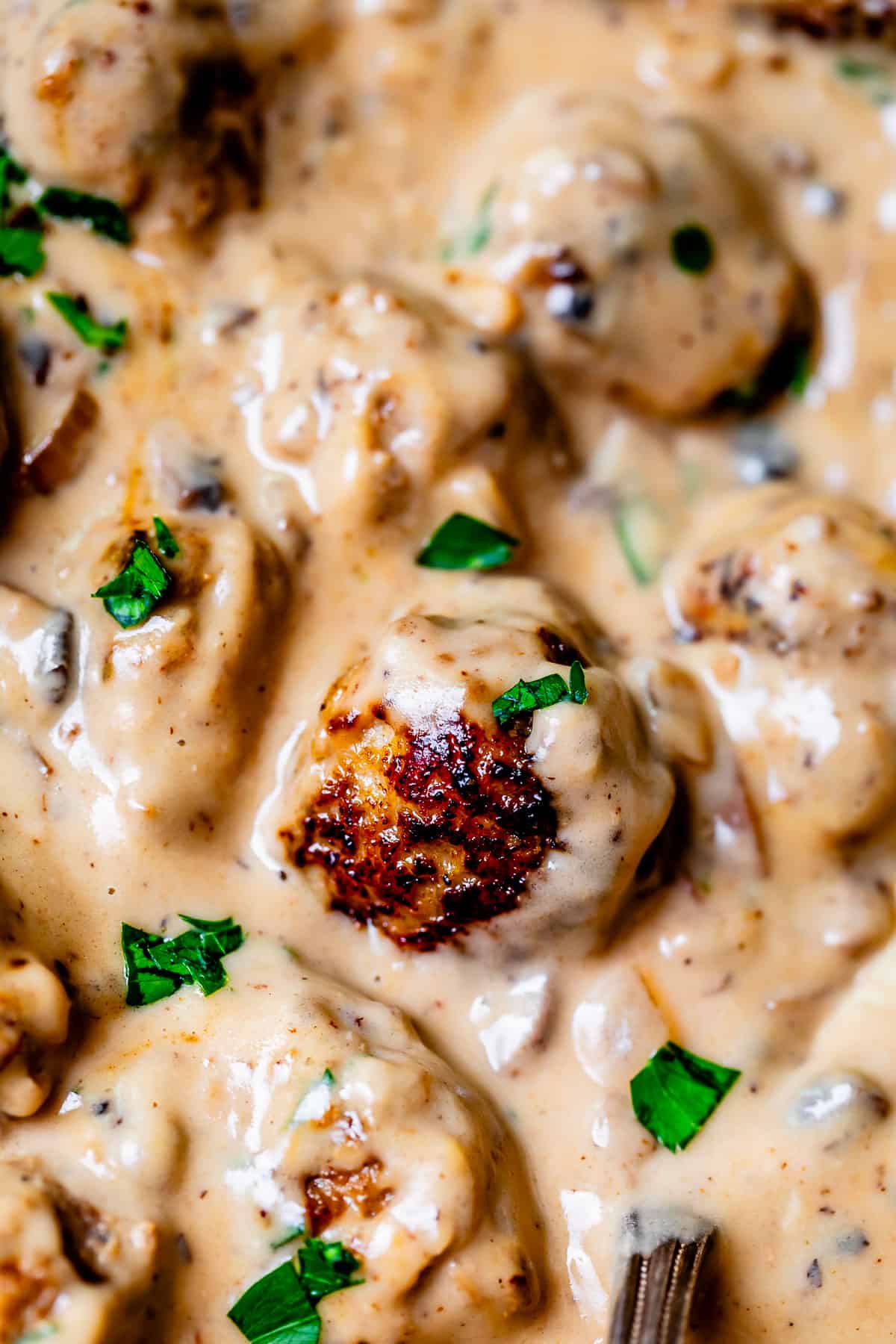 creamy, velvety swedish meatball sauce covering several meatballs.
