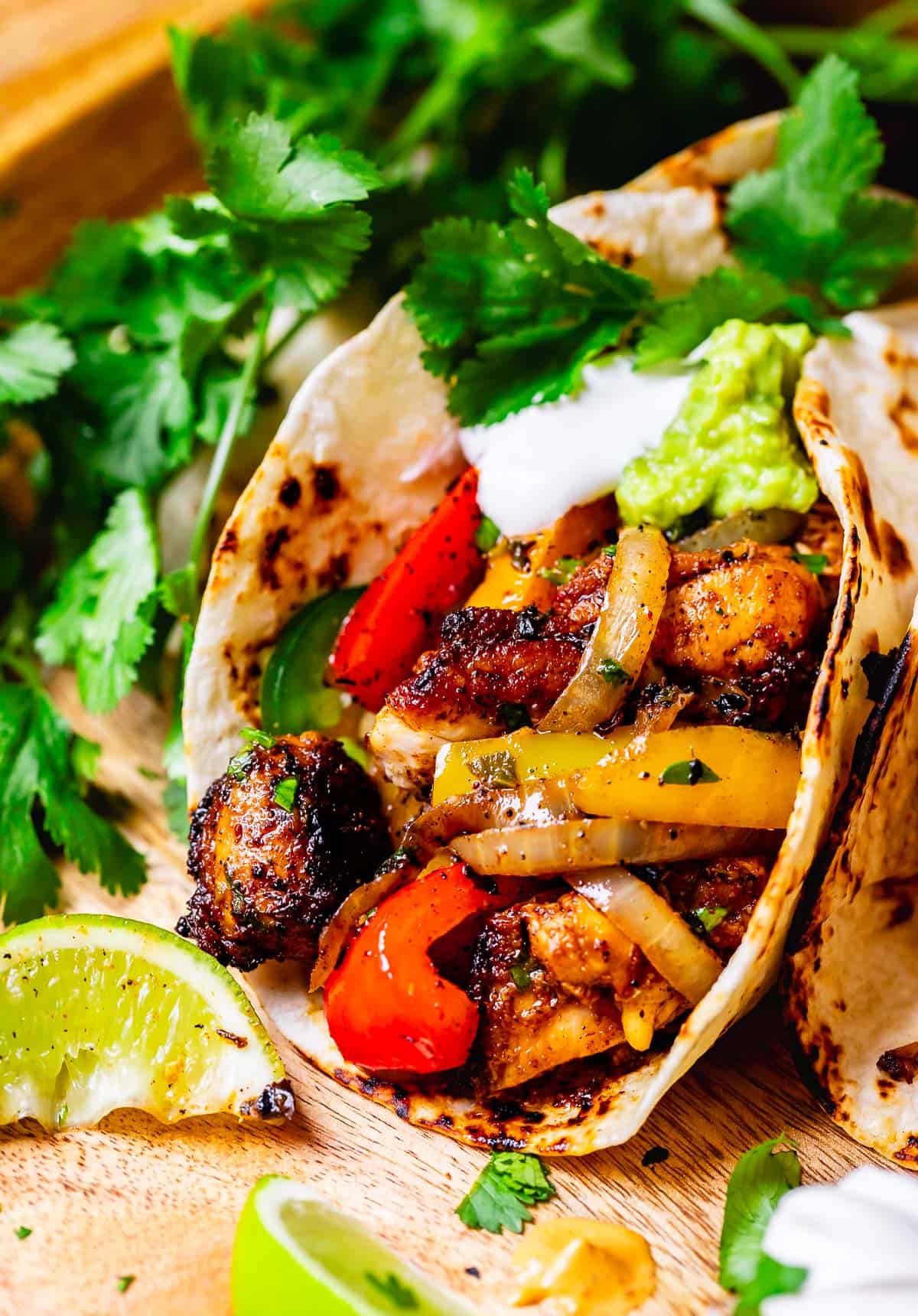 the open face of a flour tortilla stuffed with fajita chicken, onions, and bell peppers.