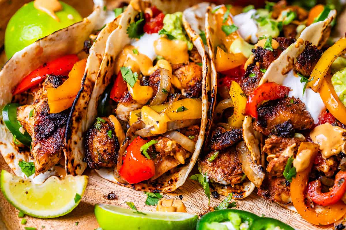 three flour tortillas stuffed full of fajita chicken, peppers, onions, topped with guacamole and sour cream.