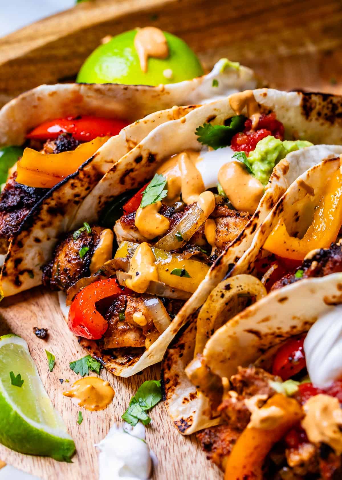 three stuffed fajitas, also topped with sour cream, salsa, guacamole, and chipotle mayo.