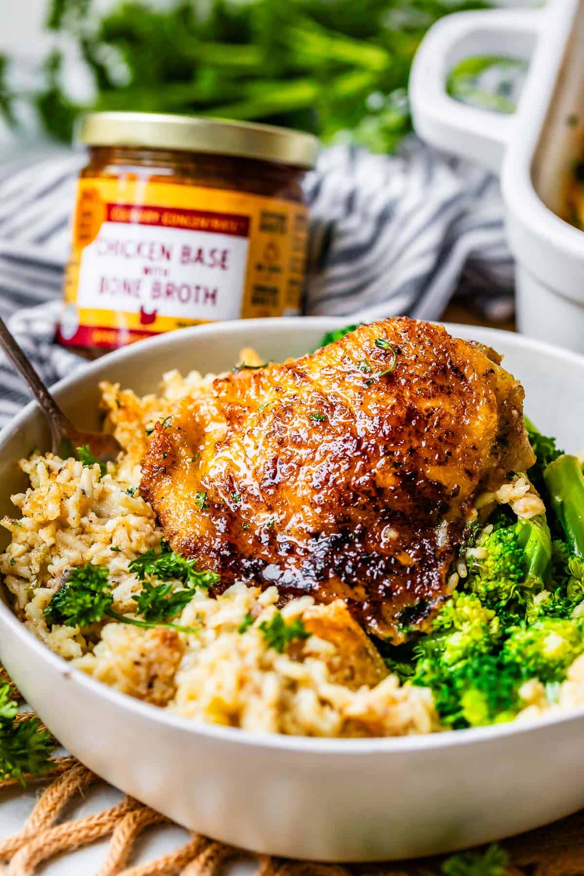 bowl filled with chicken and rice casserole and broccoli on the side.