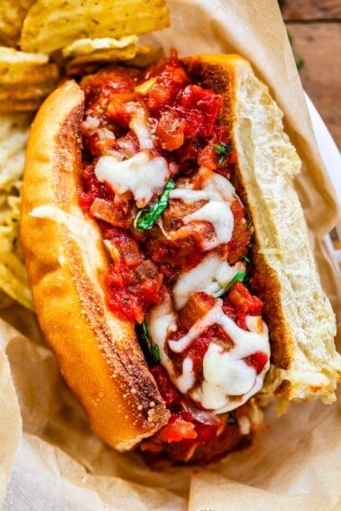 full toasted sub stuffed with meatballs in sauce and topped with cheese.