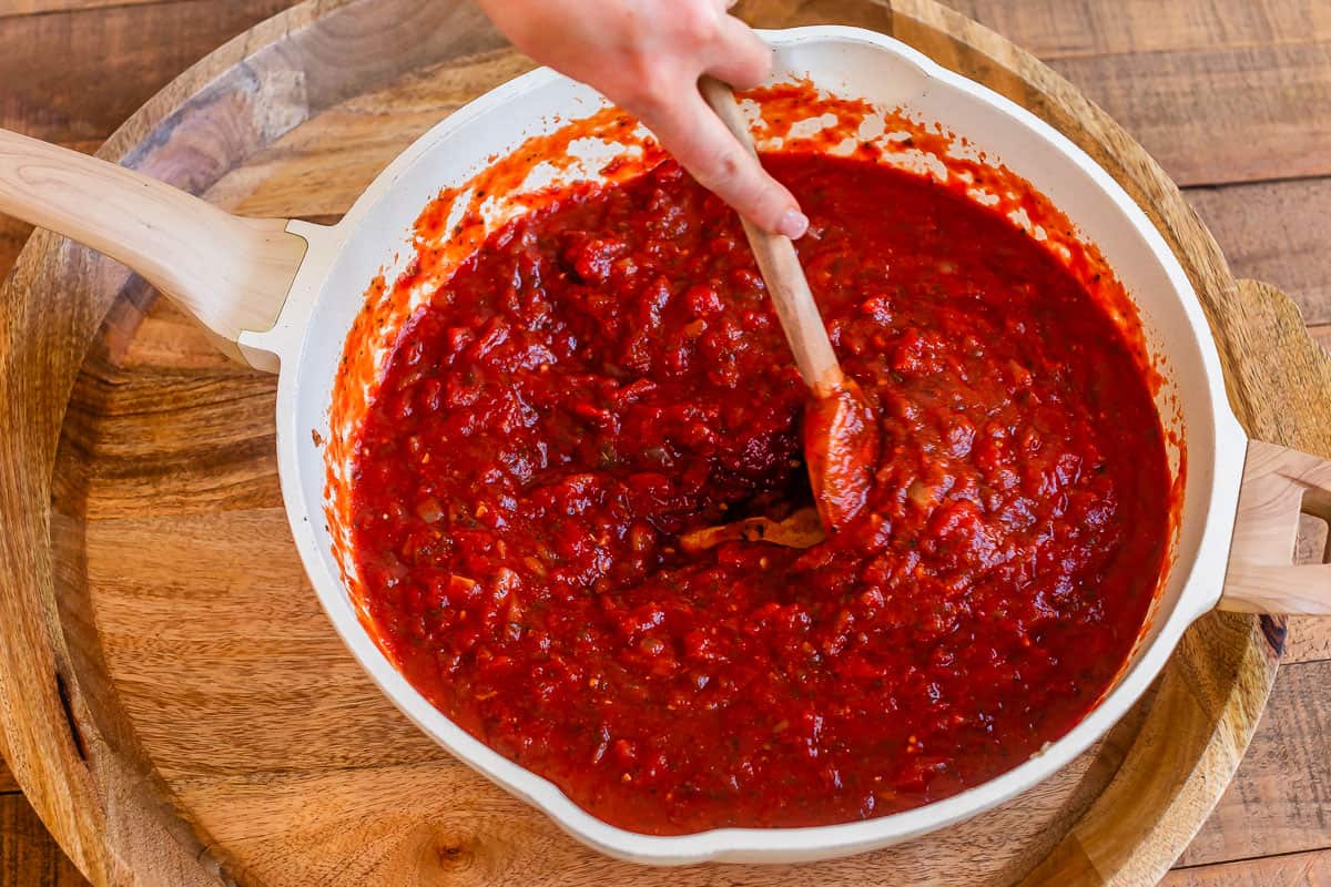 crushed tomatoes added to the pan with the spices, onions, and other ingredients.