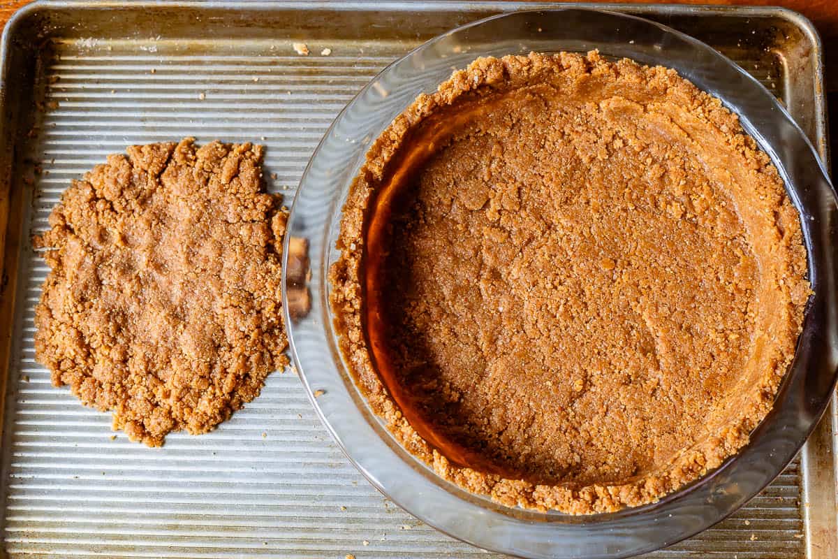 crust in pie plate on metal baking sheet, with extra crust on side to be baked for topping.