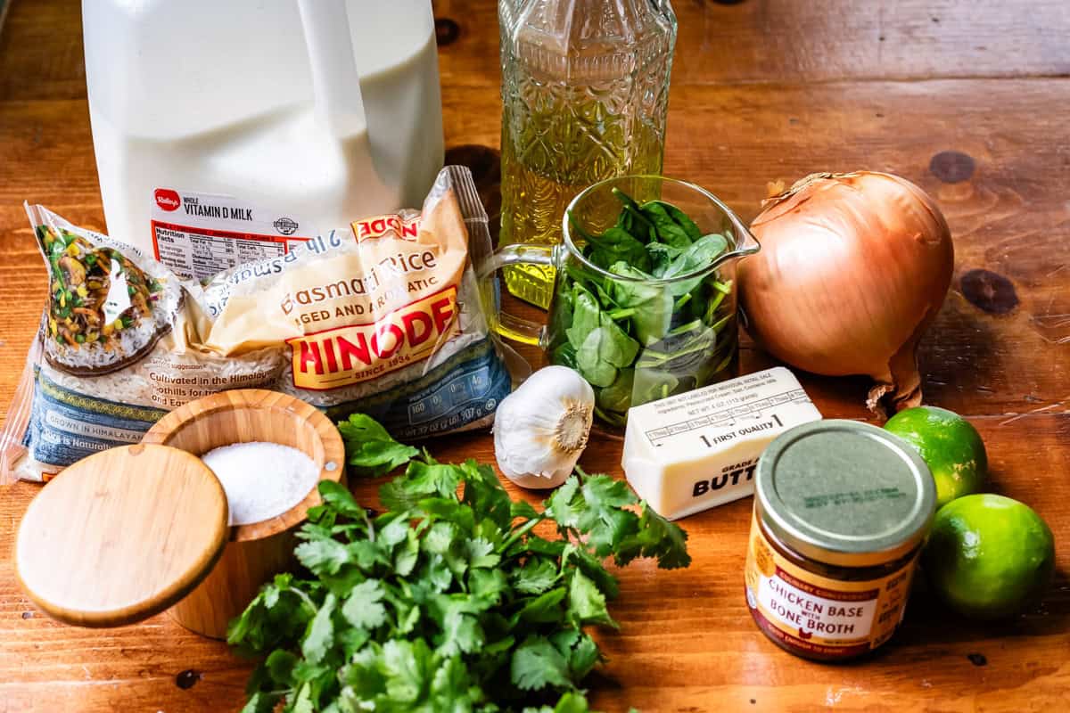 wood table with cilantro lime rice ingredients set out, like, garlic, milk, and more.