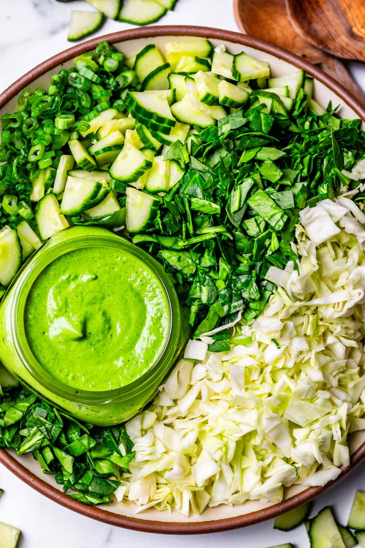 chopped salad with green goddess dressing on a ceramic plate.