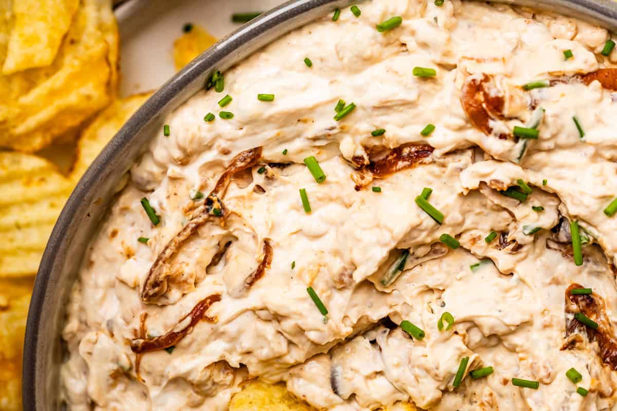 close up of French onion dip showing the creaminess as well as the bits of real, caramelized onions.