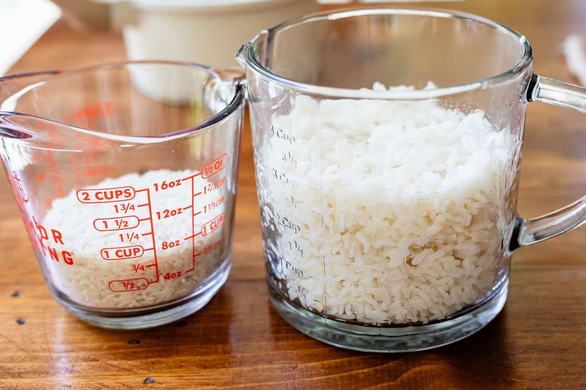 glass measuring cups showing 1 cup of dry rice and 3 cups of cooked rice.
