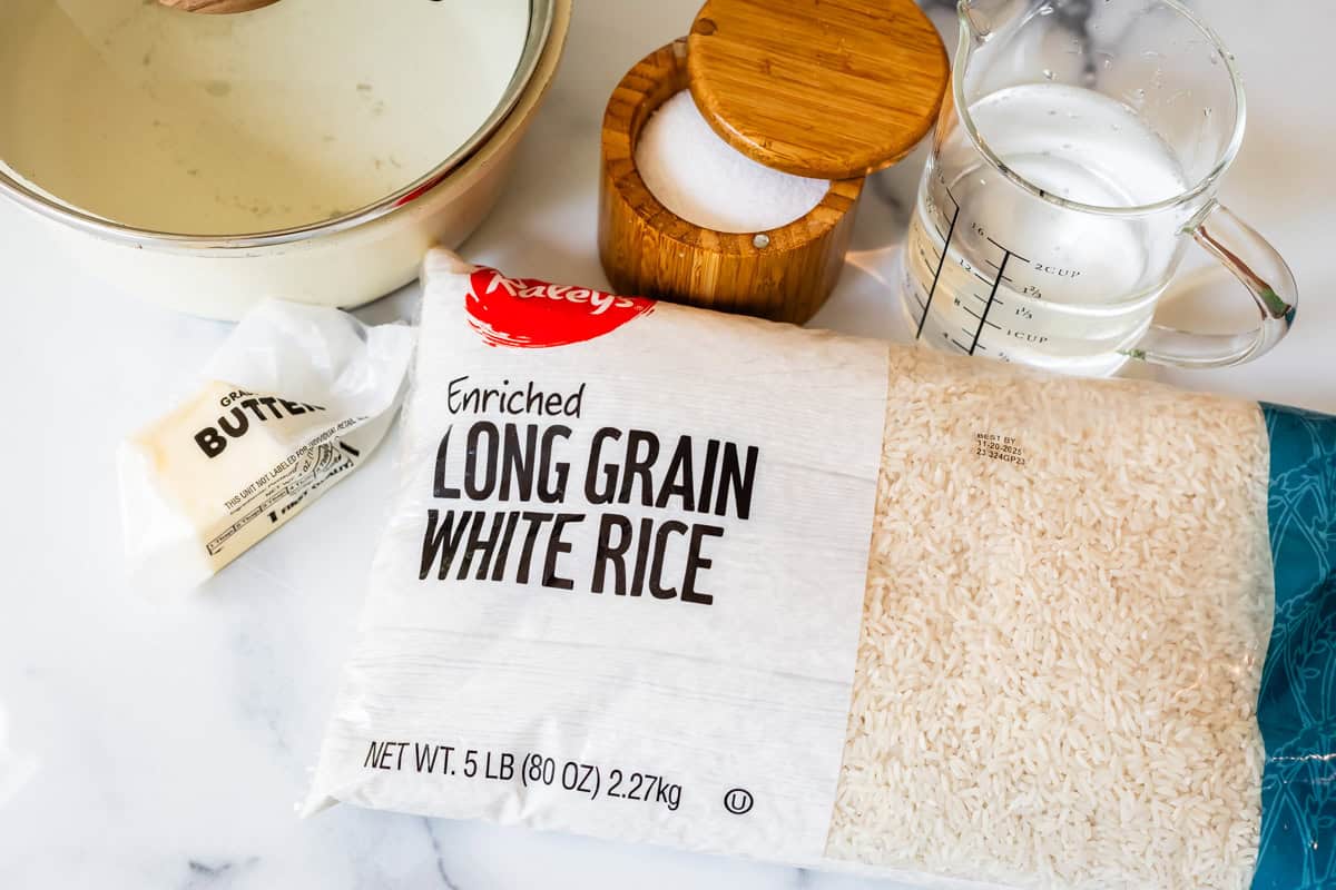 Ingredients for how to cook rice on the stove with long grain white rice, butter, salt, and water.