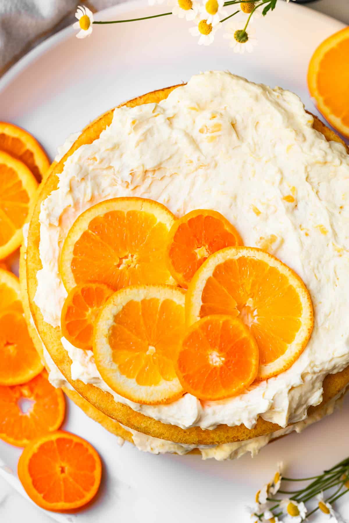 top of a round, decorated pig picking cake with orange slice garnish.