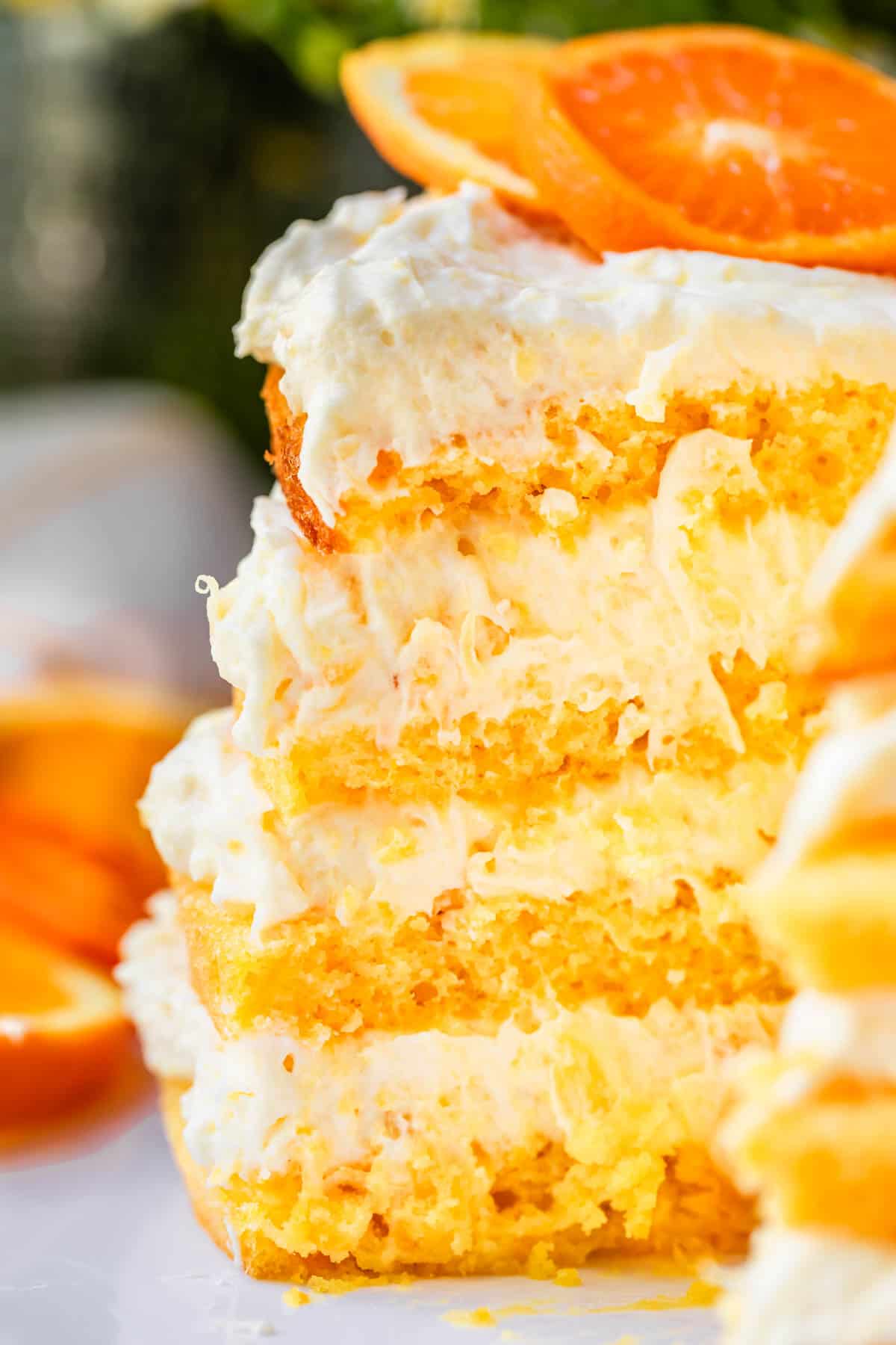 side view of all four layers each of cake and pineapple whipped cream in a slice of cake.