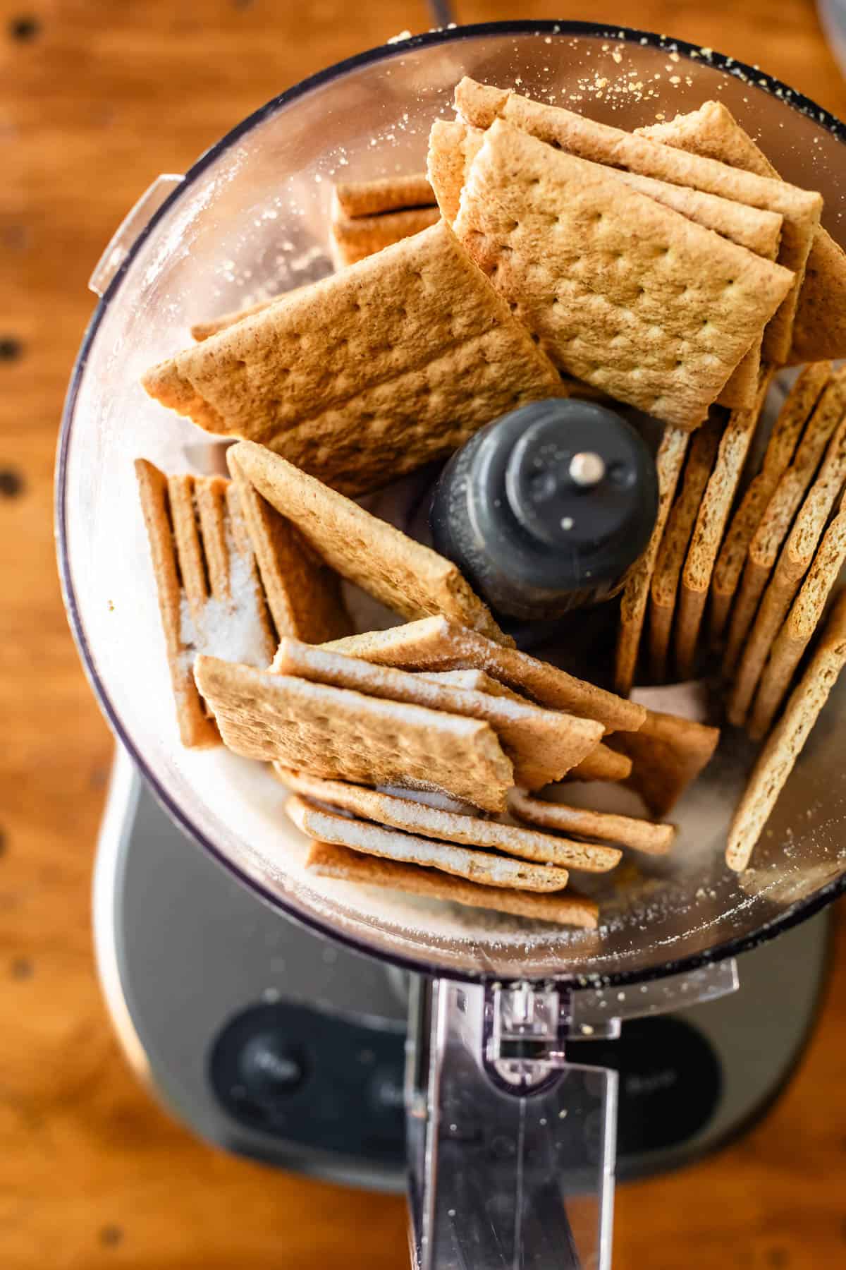 9 whole graham crackers shoved into a food processor ready to be blitzed.