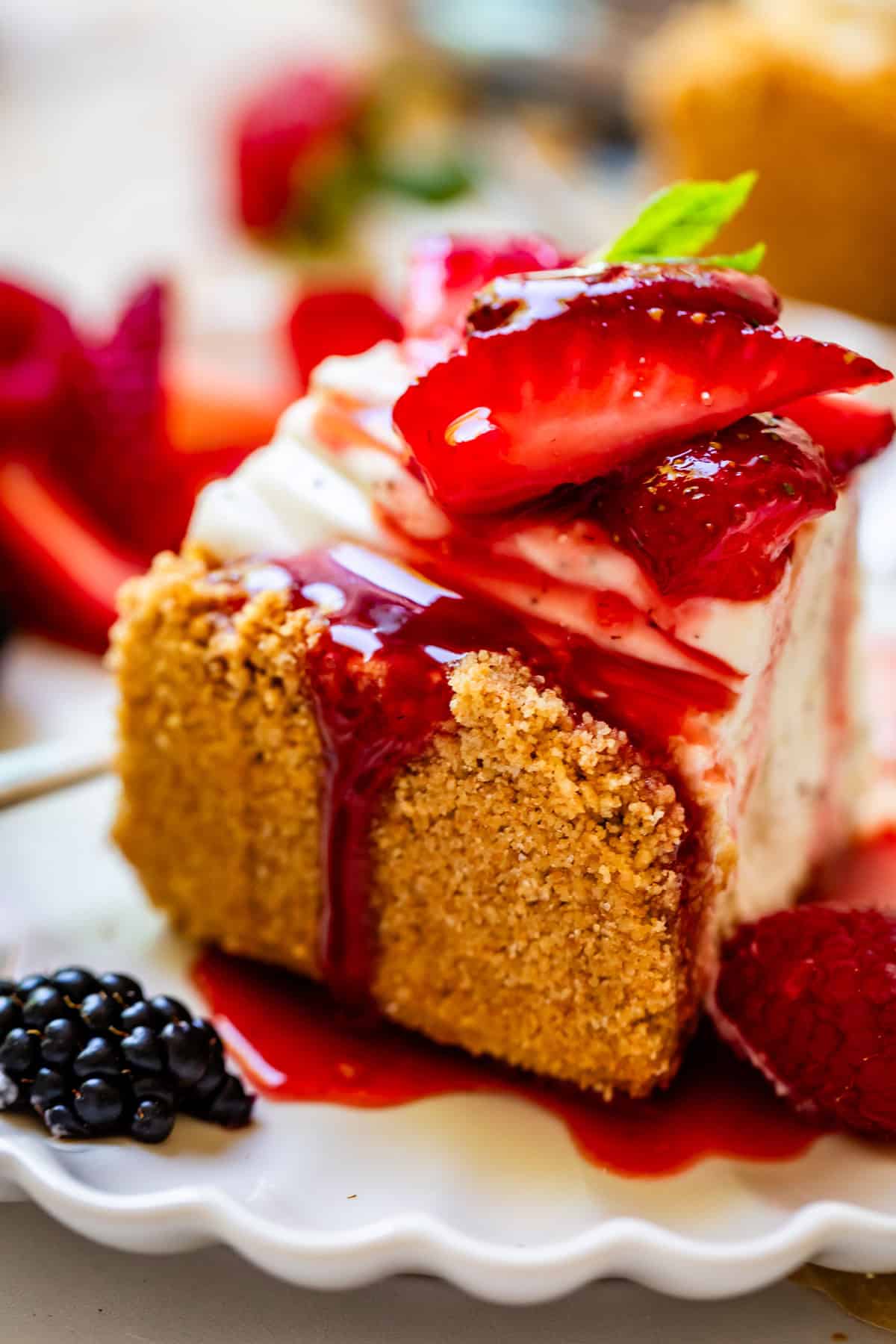 slice of no bake cheesecake showing thick crust and juicy strawberry topping.