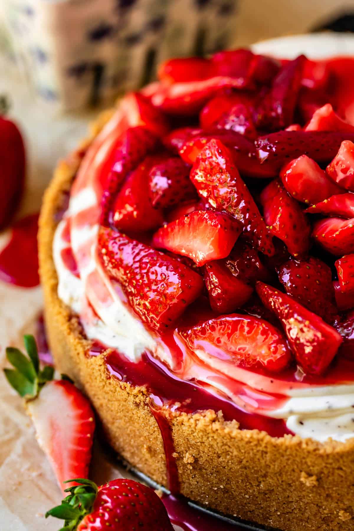 no bake cheesecake with mounded fresh strawberry topping and juice dripping down.