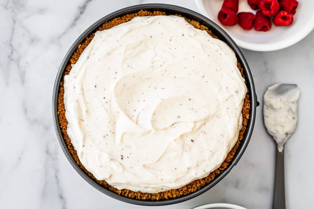 a springform pan with no bake cheesecake, showing the crust on the edges and a smooth top.