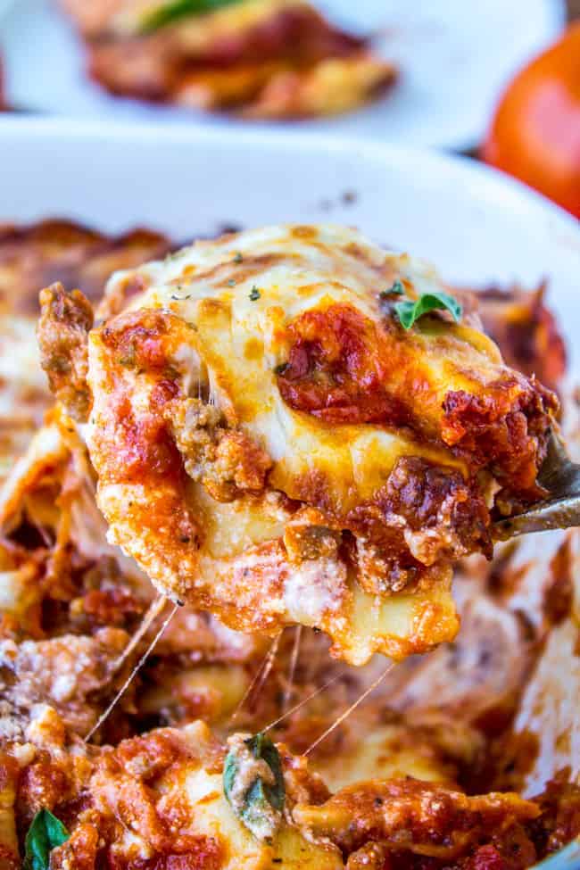 Easy Ravioli Lasagna from The Food Charlatan. This easy ravioli lasagna bake is a hearty no-brainer dinner to make on busy back-to-school nights. You don't even have to cook the ravioli, just throw it in frozen. It's a total crowd-pleaser! And a great make-ahead meal too. #ravioli #lasagna #frozen #quickdinner #ricotta #easy #cheese #mozzarella #marinara #freezermeal #makeahead a piece of ravioli lasagna.