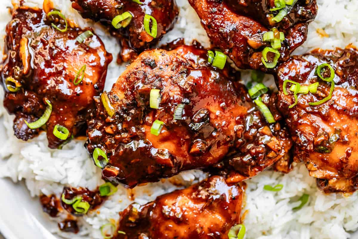 garlic honey chicken garnished with green onion served over white rice.