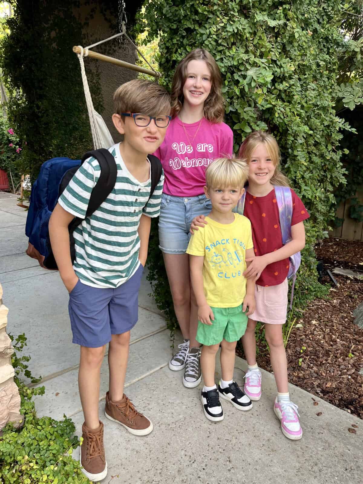 4 kids standing and smiling.