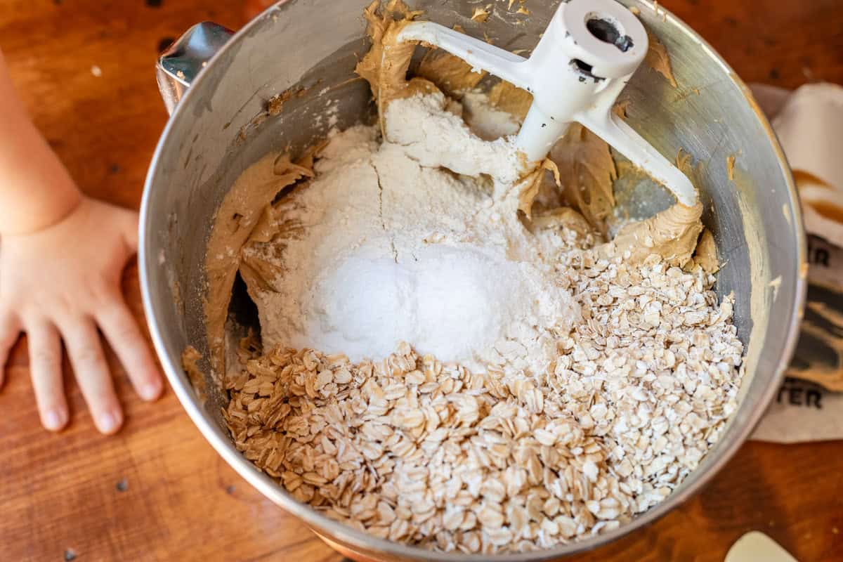metal mixing bowl with ingredients for oatmeal cookie base on top of counter.