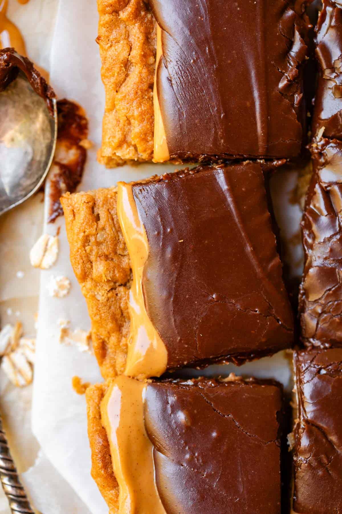 close up of three cut lunch lady cookie bars topped with rich chocolate frosting.