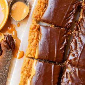 cutting board with a row and partial row of cut lunch lady peanut butter bars.