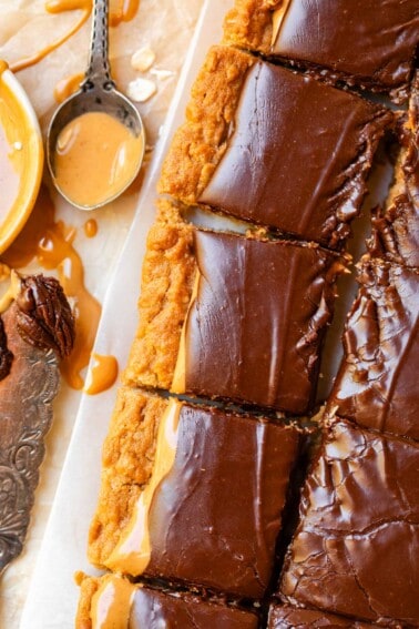 cutting board with a row and partial row of cut lunch lady peanut butter bars.