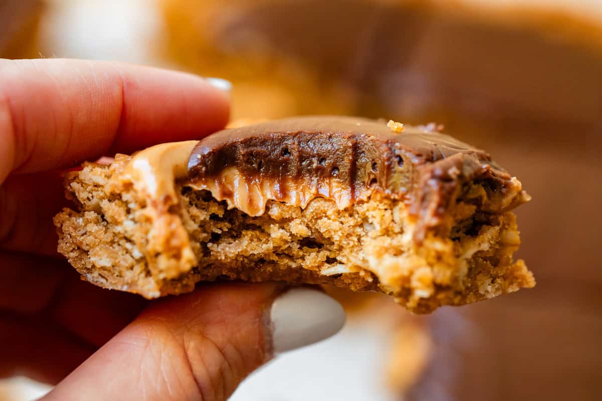 fingers holding one lunch lady cookie bar square with a large bite taken from it.