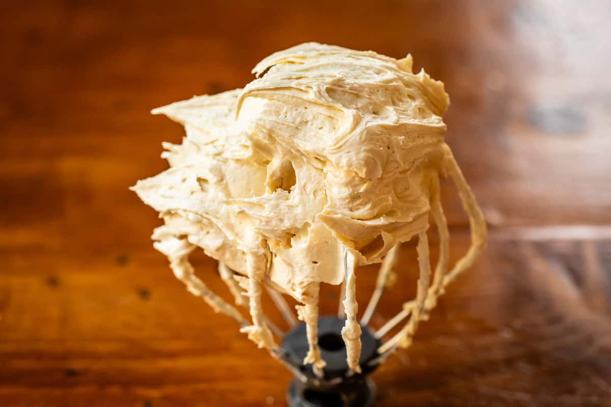 beater whisk topped with whipped honey buttercream frosting.