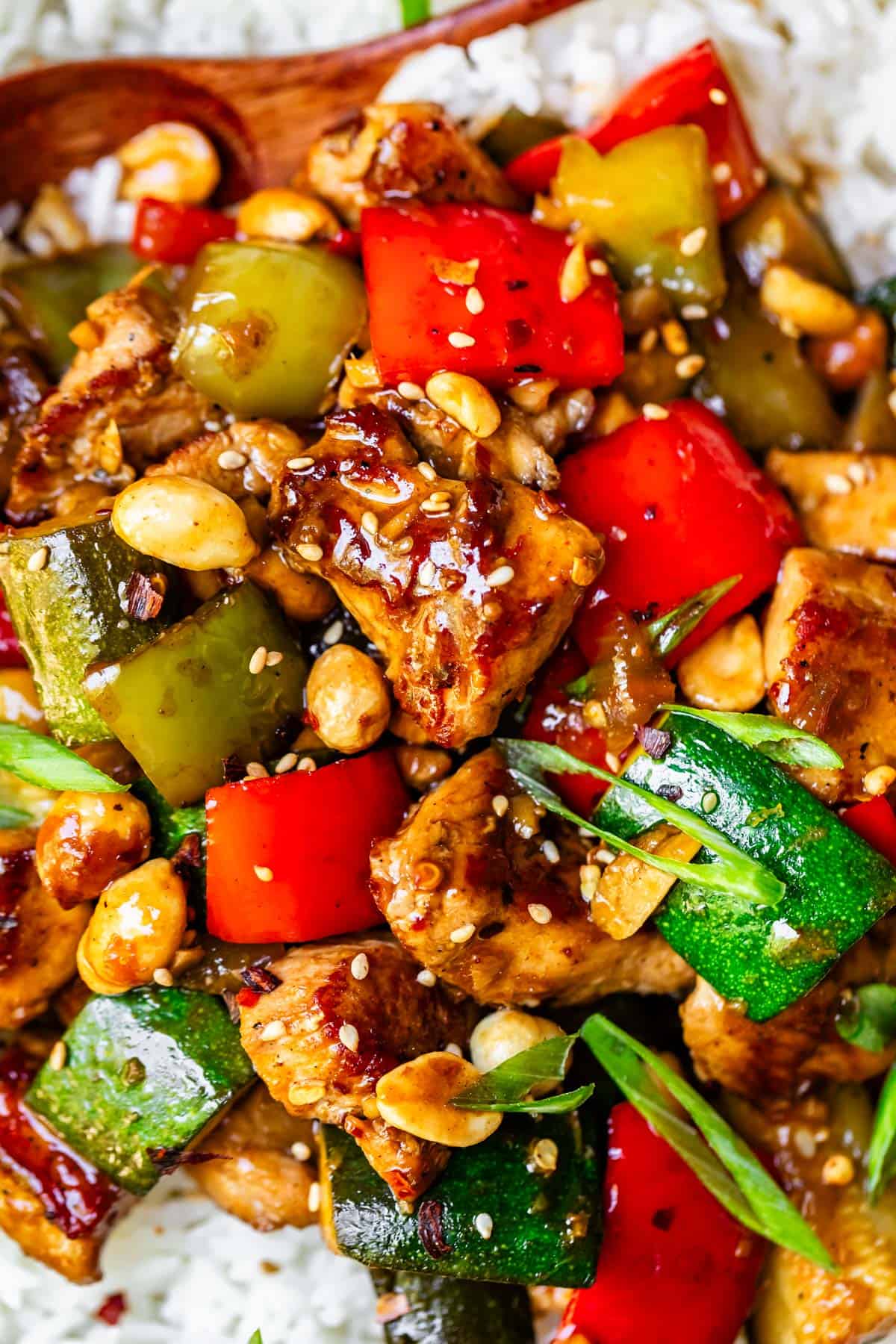 saucy chicken with zucchini, red bell pepper, peanuts, on rice.