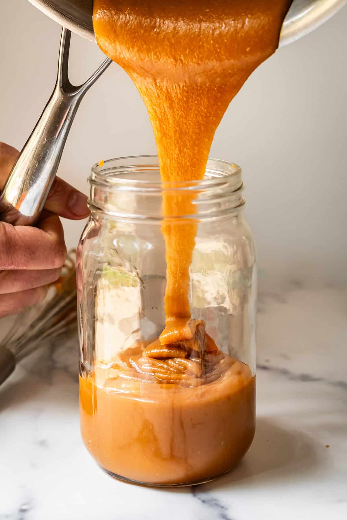 salted caramel drizzled into a mason jar from a pan.