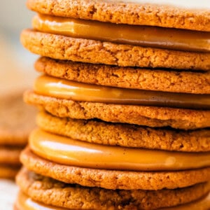 stack of four salted caramel cookie sandwiches on parchment paper.