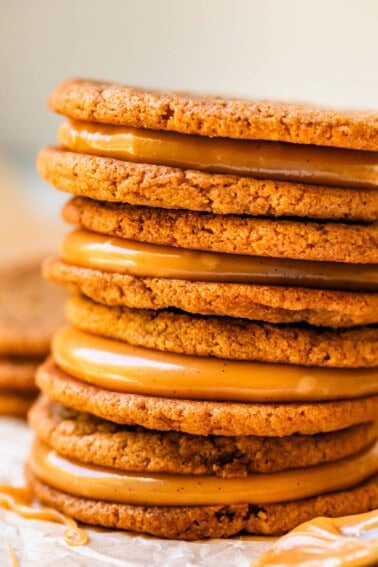 stack of four salted caramel cookie sandwiches on parchment paper.