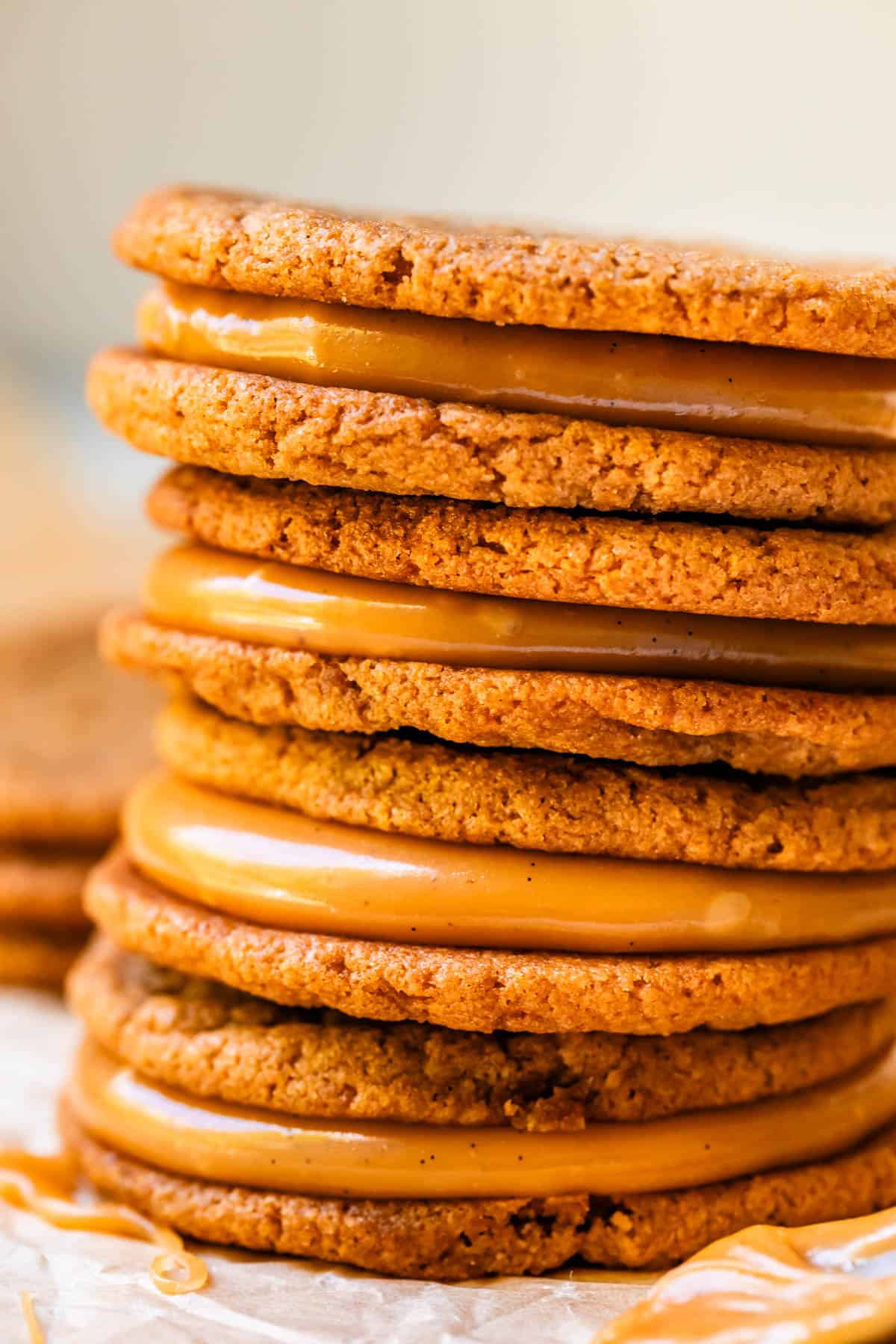 stack of four salted caramel cookie sandwiches on parchment paper.
