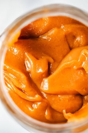 a lot of velvety salted caramel sauce in a glass jar.